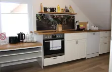 Helle vollausgestattete Küche mit Herd, Mikrowelle, Backofen, Toaster und Spülmaschine